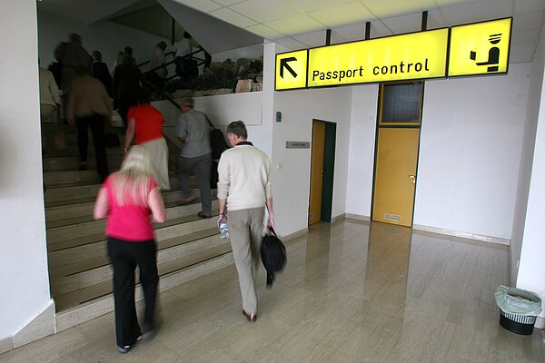 People going up a staircase to passport control.